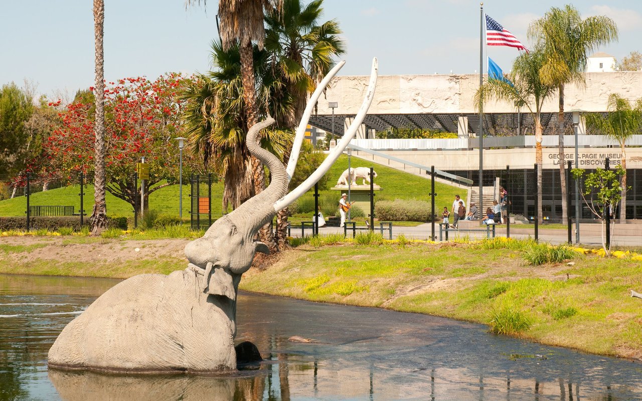 La Brea Tar Pits beside the George C. Page Museum, with a large mammoth sculpture.
