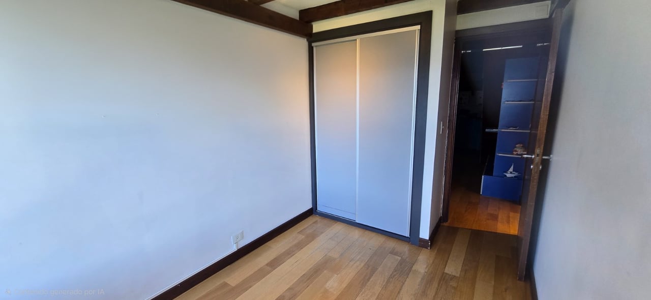 Empty room with wood flooring, a built-in sliding-door closet, and an open doorway.