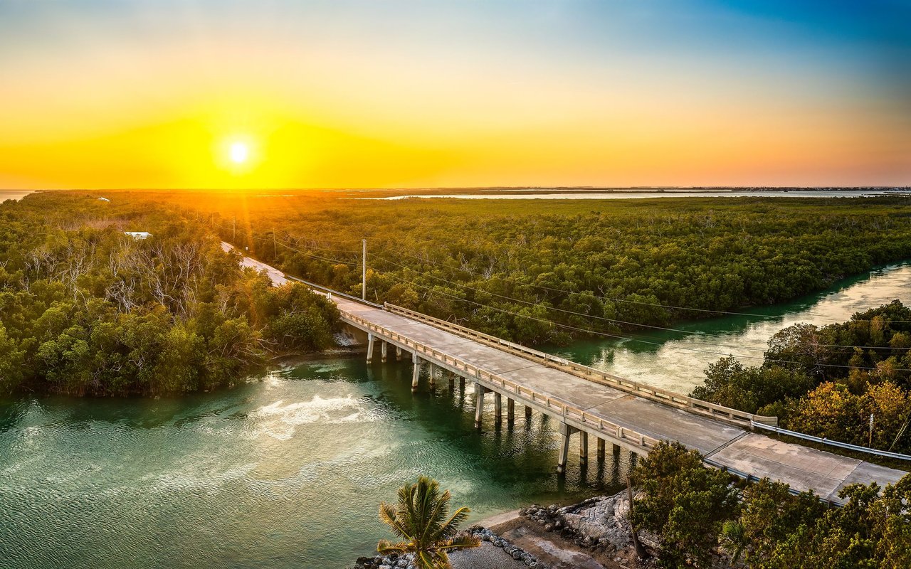 A bridge crosses turquoise water and mangroves in the Saddlebunch Keys at sunset.