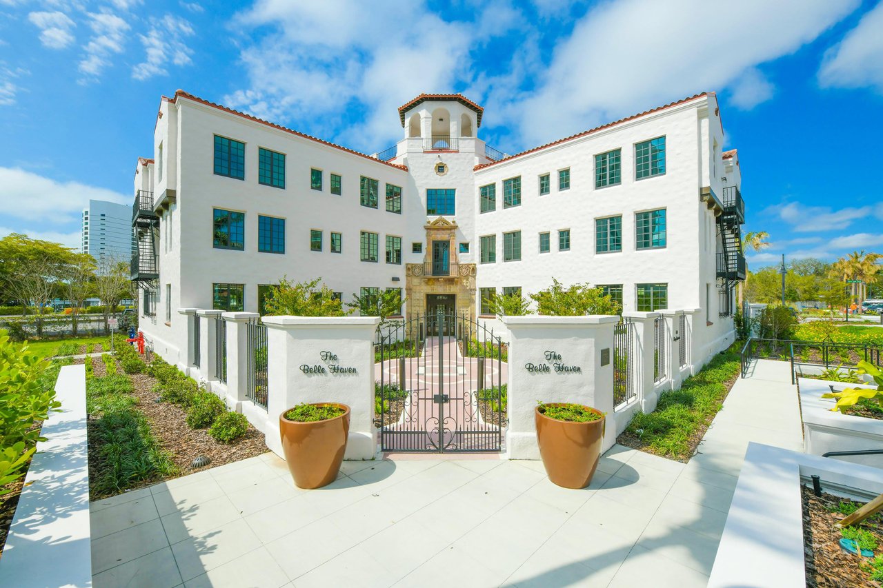 Belle Haven condominium building with a central tower, gated entrance, and landscaped courtyard.