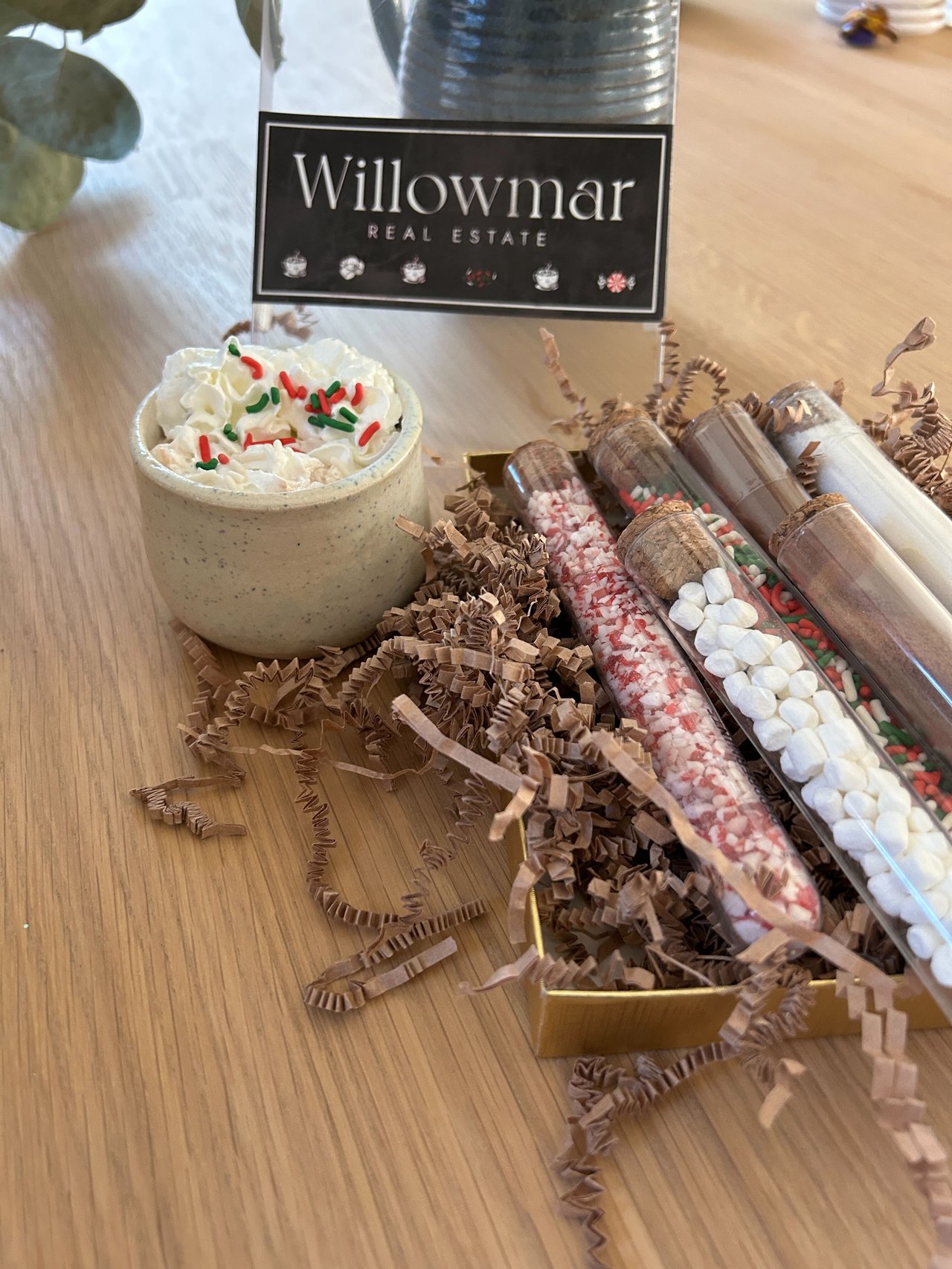 Willowmar Real Estate gift display with cocoa, marshmallows, and colorful treats.