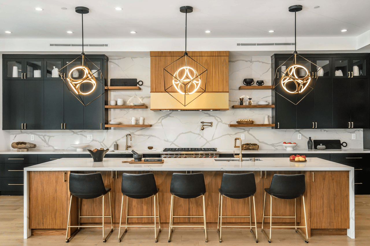 Modern kitchen with a marble backsplash, wood island, dark cabinets, and three geometric pendant lights.