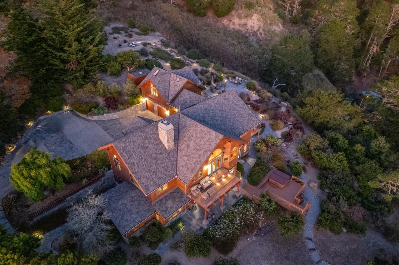 Aerial drone view of a home highlighting its large lot, surrounding natural scenery, and nearby features