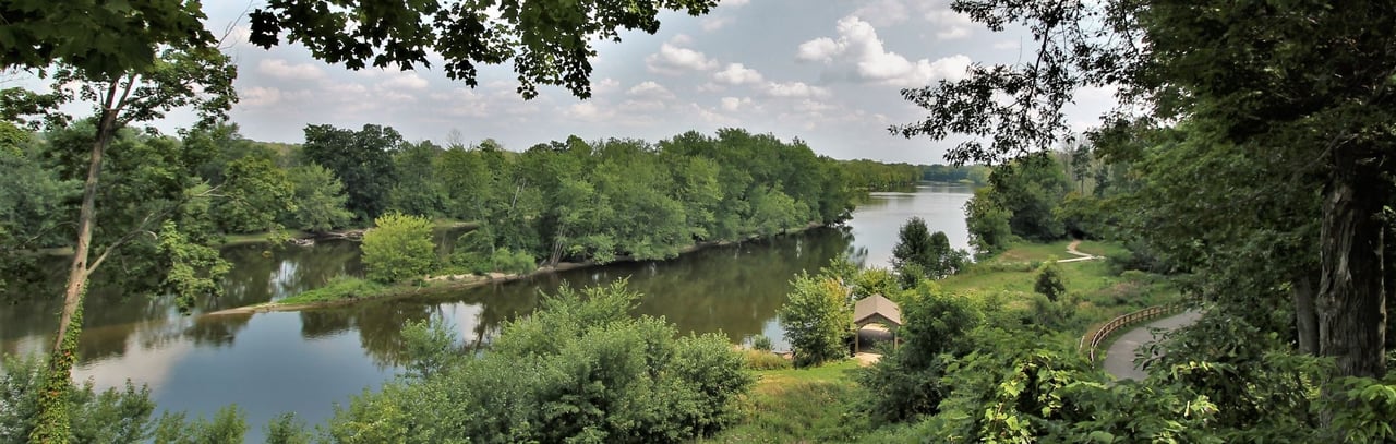 Scenic view of the Grand River at Grand River Park in Jenison, Michigan with trees, trails, and river overlook.