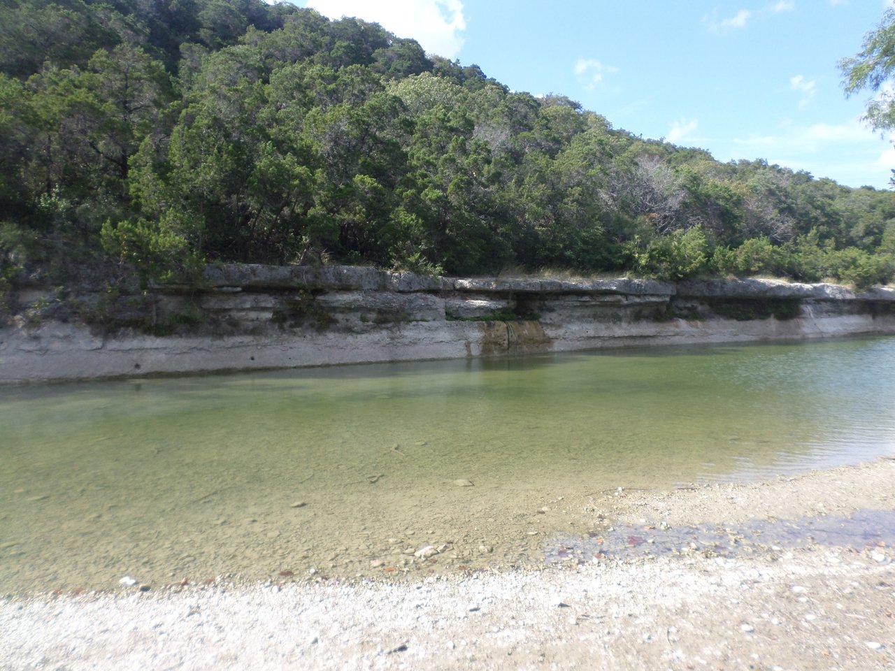 Here's a thorough, honest breakdown of whether Barton Creek Austin is worth the price tag in 2026 — covering the market data, the lifestyle value, the hidden costs, and the real trade-offs.  ---  # Is Barton Creek Austin Worth the Price Tag in 2026?  ## The Current Market Snapshot  Barton Creek home values currently sit in the $2.18M–$2.22M average range, with a modest 3.1% year-over-year increase. Price per square foot runs from $513 to $553, with premium properties in Barton Creek West commanding $600–$750 per square foot or higher.  Here's the data puzzle that matters most for buyers right now: overall home values are up 3.1% year-over-year, yet price per square foot is down compared to the 2022 peak. The explanation lies in what is selling — larger homes and estate-sized properties are transacting at higher absolute prices, but because those homes carry more square footage, the per-foot metric compresses even as total price rises.  Critically, there's a noteworthy split happening across the broader Austin market. The Barton Creek ZIP code (78735) posted the largest year-over-year median price decline of any ZIP code in the metro, falling about 18.1% — from roughly $1.52M to $1.25M. This reflects weakness specifically in the upper-mid-luxury tier, which has not benefited from the same flight-to-quality dynamic lifting Westlake and Bee Cave. Serious buyers should understand this nuance: while the area's ultra-luxury tier is holding up, the broader ZIP code data is softer.  ---  ## The Buyer Leverage Window  Barton Creek homes are currently selling at approximately 9–10% below list price, which can translate to $180,000–$220,000 in savings on a typical transaction. On a $2.5M home, a 9–10% reduction translates to approximately $225,000–$250,000 below the asking price.  This window of buyer leverage is real but not permanent. When rates decline, competition returns quickly and the negotiation discount will compress. So if Barton Creek is on your radar, 2026 may represent a genuine opportunity — not to catch a falling knife, but to buy into a supply-constrained neighborhood at a meaningful discount from peak.  ---  ## Why Barton Creek Holds Its Value (The Real Moat)  Three structural factors protect Barton Creek from the steeper corrections seen elsewhere in Austin:  **1. Environmental supply restrictions.** The Save Our Springs Ordinance limits impervious cover to 15–25% on properties within the Barton Creek watershed, and the Edwards Aquifer Recharge Zone regulations physically restrict renovation scope, addition square footage, and new construction density in ways that have no equivalent in other Austin luxury neighborhoods. Less new supply means existing homes hold their value better.  **2. School district premium.** Barton Creek falls within Eanes ISD, which Niche ranks #1 in Texas and #7 nationally as of 2026. Families relocating from California, New York, and Seattle consistently cite Eanes ISD as their primary reason for targeting Barton Creek, Westlake Hills, or Rollingwood. The school premium is real, measurable, and durable — but buyers should verify school zoning by exact address, as not all Barton Creek properties are zoned to Eanes ISD; some streets and sub-communities fall within Austin ISD boundaries, which can represent a significant price differential.  **3. Lifestyle infrastructure.** The Barton Creek Country Club offers four championship courses designed by Arnold Palmer, Ben Crenshaw, and Tom Fazio — Fazio Foothills, Fazio Canyons, Crenshaw Cliffside, and Palmer Lakeside. Add to that a resort spa, fitness center, tennis courts, and over 12 miles of Greenbelt trails next door. This is a lifestyle package with no true equivalent in West Austin.  ---  ## The Sub-Community Trap Most Buyers Fall Into  This is the single most important thing serious buyers need to understand: **Barton Creek is not one neighborhood.**  Barton Creek's sub-community structure creates a $5M+ price range within the same ZIP code — from The Estates at $1.5M–$2.5M to Barton Creek West at $3M–$7M.  The community is organized into 6 distinct enclaves, each with its own HOA, price tier, and character. Barton Creek West has the newest construction and highest price points. Amarra Drive features contemporary custom homes on premium lots. The Preserve and Collections sections offer more attainable entry points.  Treating "Barton Creek" as one neighborhood is the fastest way to overpay or buy in the wrong pocket.  ---  ## The True Cost of Ownership (The Honest Part)  The purchase price is just the beginning. HOA fees range from approximately $200 to over $800 per month depending on which sub-community a home falls within.  On top of that: certain sections of Barton Creek are subject to Water Control and Improvement District (WCID) fees, paid in addition to standard property taxes and HOA dues. These can add $3,000 to over $8,000 annually on a $3M property — a crucial cost layer that buyers rarely encounter in Tarrytown or Rollingwood.  A $2M home in Barton Creek can carry $5,000–$8,000 per month in non-mortgage costs. Run those numbers before you fall in love with a listing.  Country club membership is separate. You can live in Barton Creek without joining the club, but if you don't use the country club, you're paying for amenities that sit unused. Initiation fees and monthly dues are not publicly listed — request the current written schedule directly from the membership office.  ---  ## The Honest Drawbacks  Some sections have homes built in the 1980s and 1990s that show their age. Drainage can be tricky on hillside lots after heavy rain. The HOA rules in certain sections are strict enough to frustrate buyers who want full control over their landscaping or exterior finishes.  The commute is another real consideration. Unlike Tarrytown or West Lake Hills — which sit closer to downtown — Barton Creek trades urban proximity for seclusion. If you work downtown five days a week and don't use the golf courses, the calculus shifts.  ---  ## How It Compares to Alternatives  Barton Creek generally offers a lower price per square foot ($553–$668) compared to West Lake Hills ($756+), while delivering a resort-style lifestyle centered on the Omni Barton Creek Resort, Hill Country terrain, and gated seclusion.  Compared to urban luxury alternatives like Tarrytown and Pemberton Heights, Barton Creek trades walkability and proximity for privacy, acreage, and a natural setting. The right choice depends entirely on how you actually want to live.  ---  ## The Bottom Line  **Barton Creek is worth the price tag in 2026 — but only for the right buyer.** If you have school-aged children, value privacy and acreage over walkability, use (or plan to use) the country club amenities, and are buying in the $2M+ tier with a long time horizon, the fundamental value proposition is sound. Supply constraints, Eanes ISD, and Greenbelt access create durable demand floors that protect resale.  If you're buying primarily for investment upside without the lifestyle fit, the ZIP code's recent price softness and the layered carrying costs make the math trickier. And if you're budget-sensitive at the $1.5M–$2M level, the older housing stock in some sections and the HOA/WCID fee structure deserve serious scrutiny before signing.  The 2026 buyer leverage window — with homes closing 9–10% below list — makes this a better entry point than it's been in years. But go in with eyes open on true cost of ownership, and verify school zoning, HOA structure, and enclave-specific pricing before you write an offer.