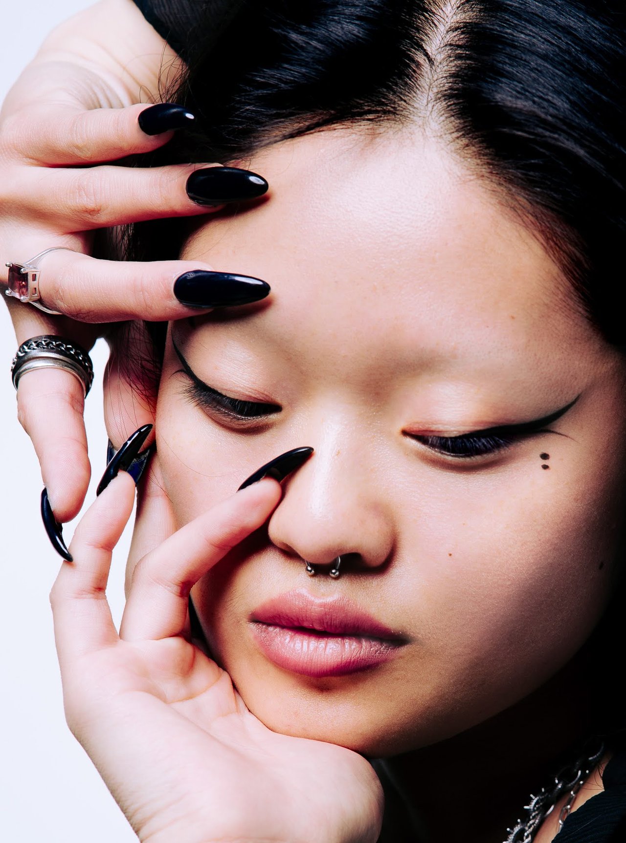 Dancer Jin with long black nails framing her face and a septum piercing