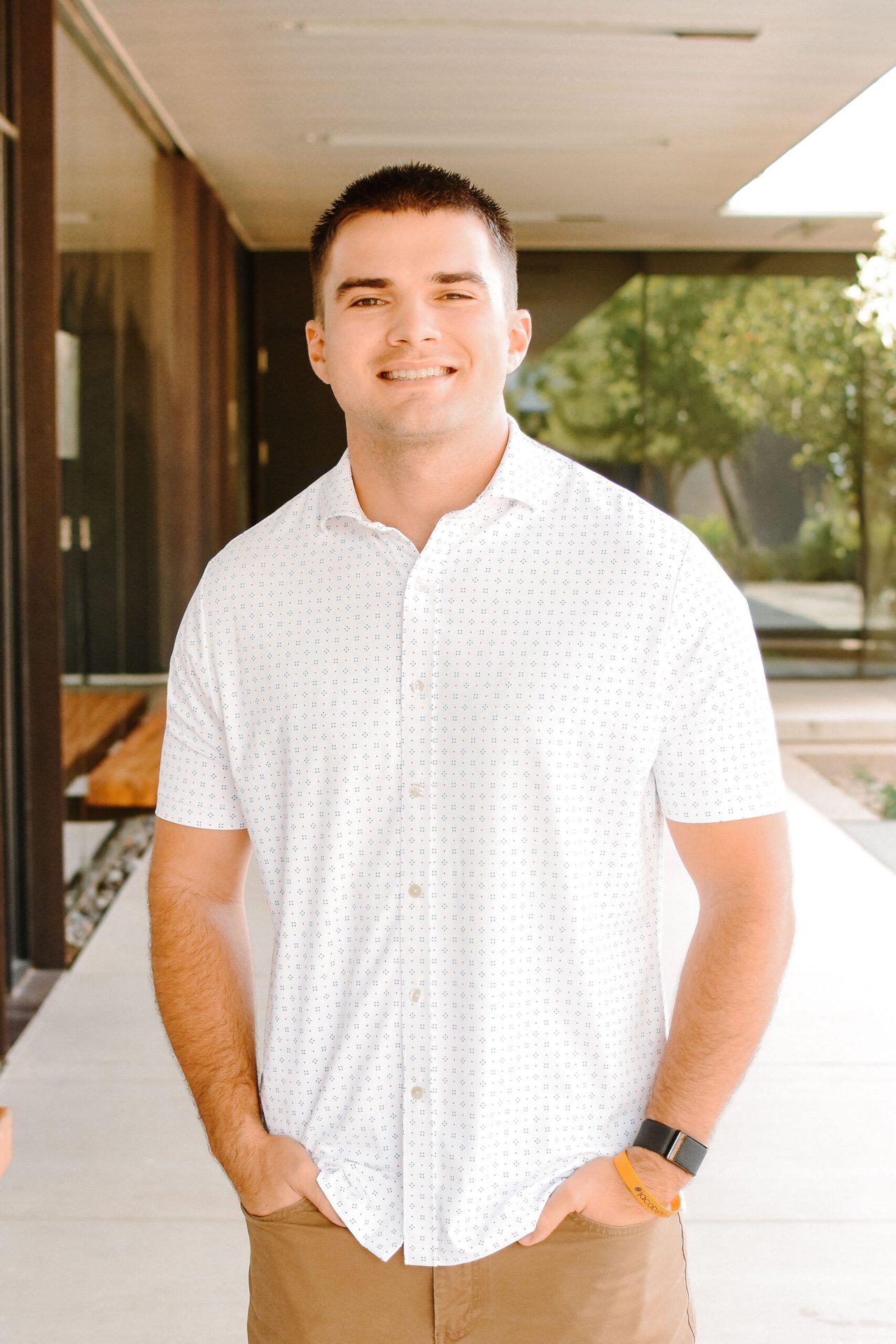 Brycen Tambone standing outside a building in a patterned white shirt.