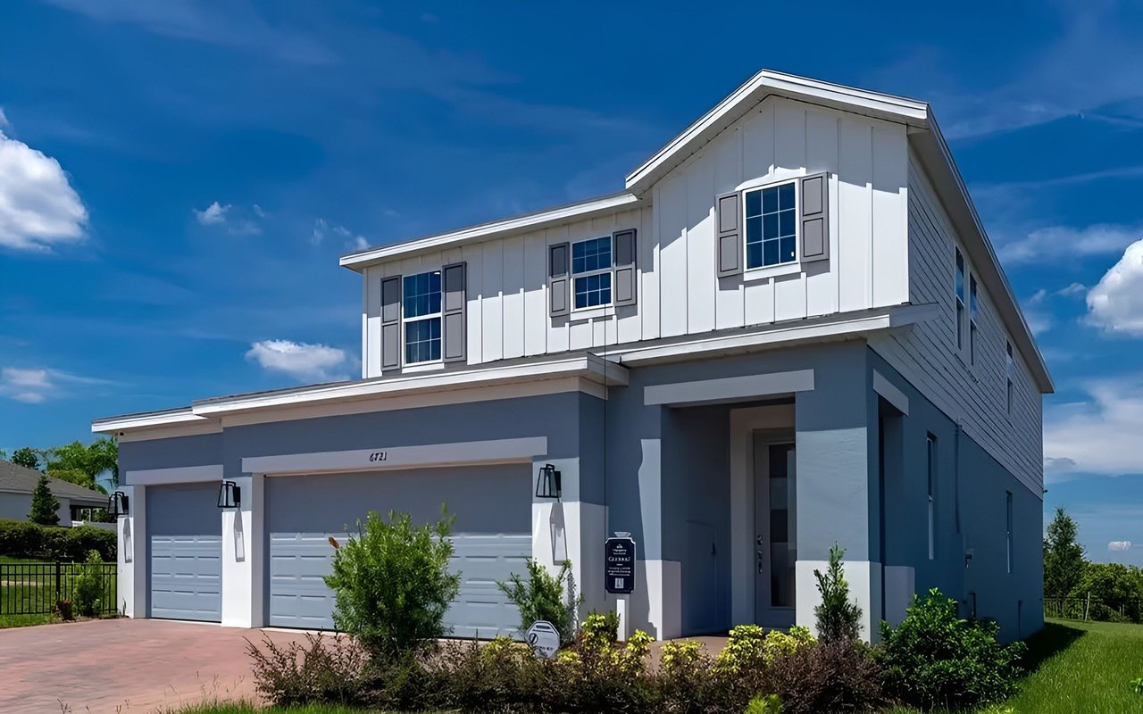 Two-story gray-and-white house with a double garage and landscaped front yard.