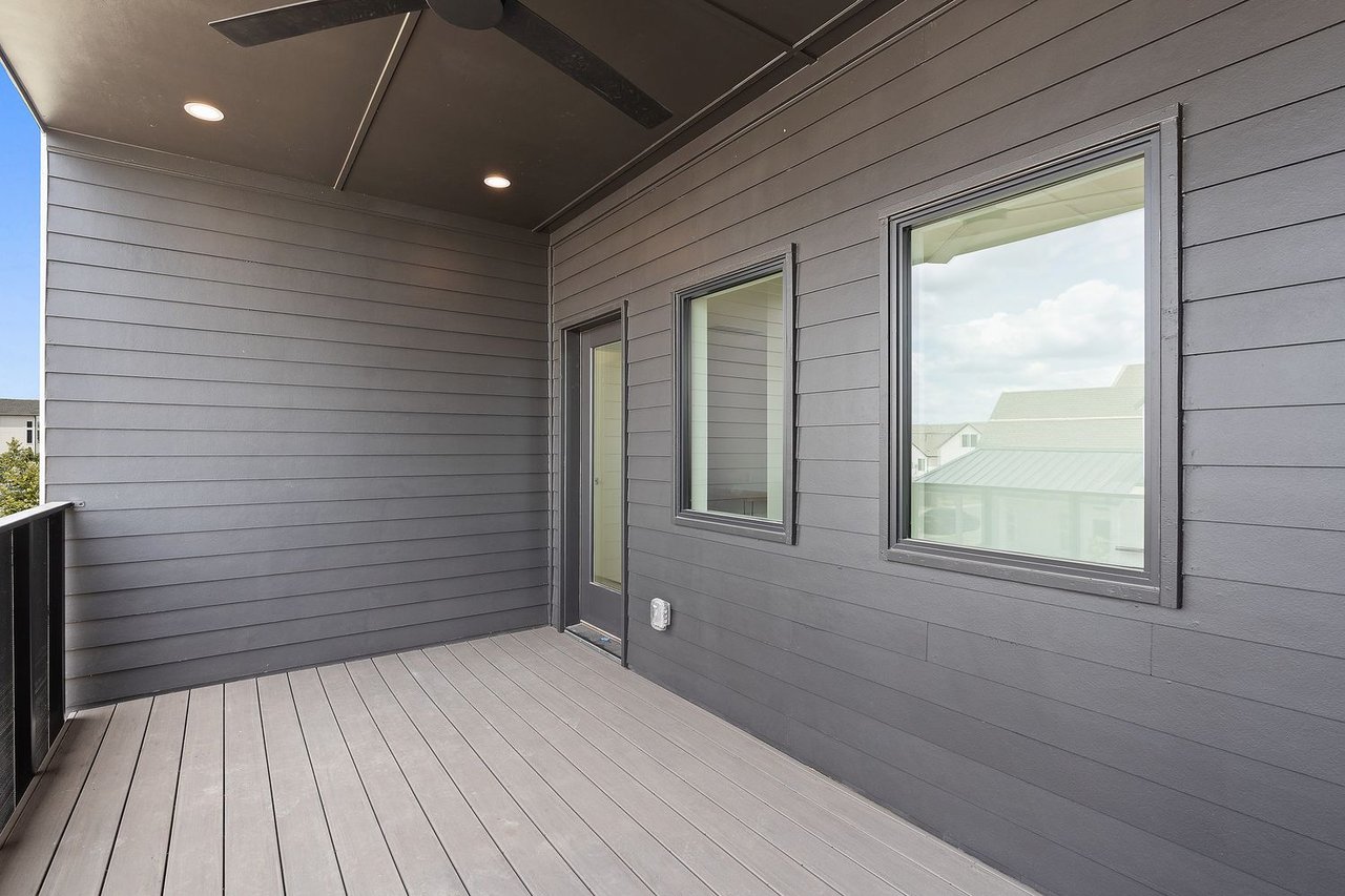Covered deck with gray siding, ceiling fan, recessed lights, and windows.