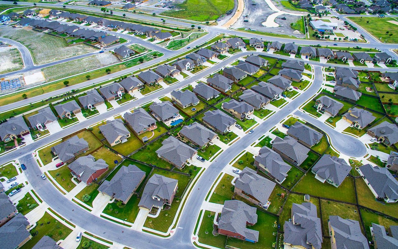 Aerial view of a suburban neighborhood with detached homes and curving streets.