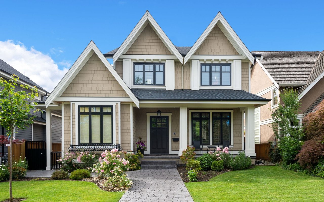 A large, two-story house with a brick exterior design and a gray shingled roof.