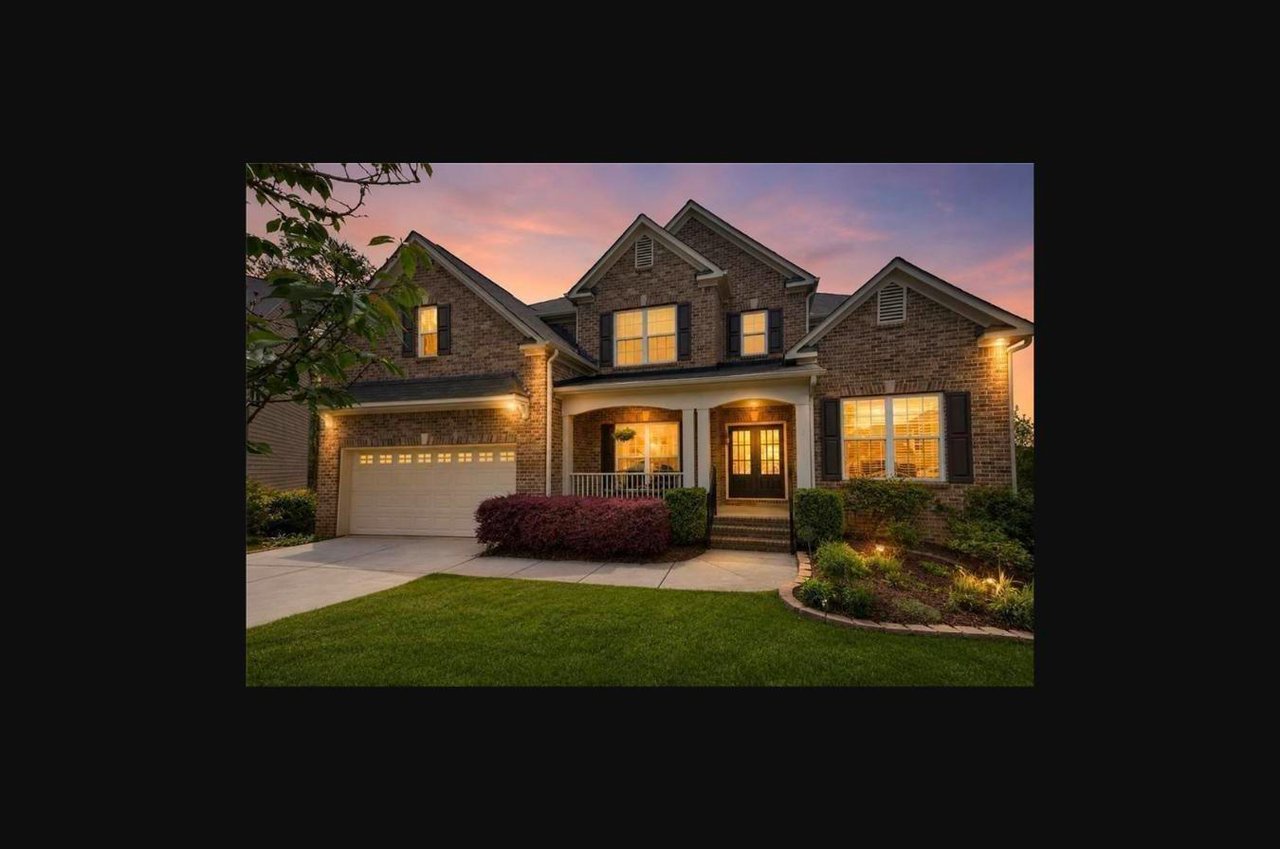 Twilight exterior of a six bedroom brick home at 3070 Blackstock Drive in Cumming, Georgia