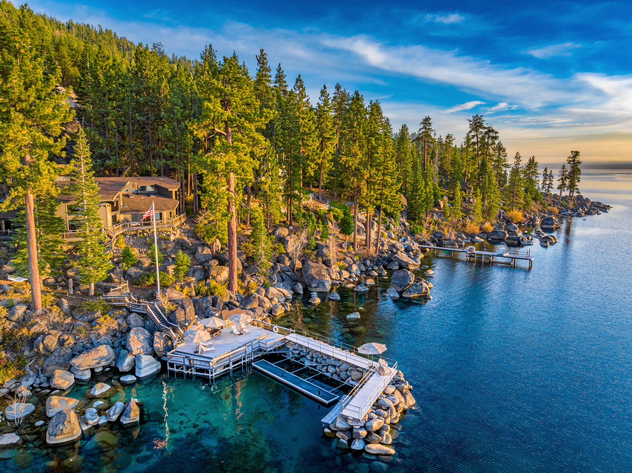 Aerial view of a Lake Tahoe waterfront home with rocky shoreline and private docks.