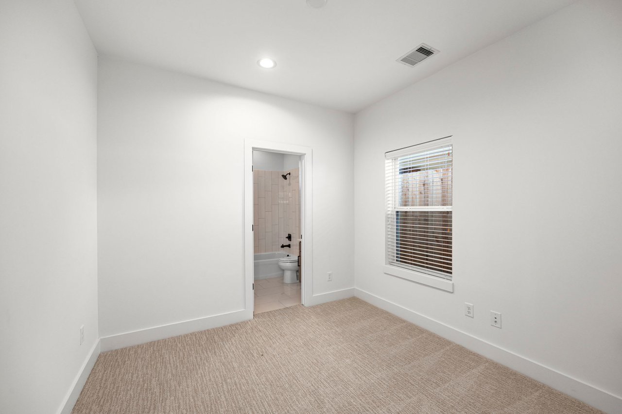 unfurnished guest bedroom with an ensuite bathroom