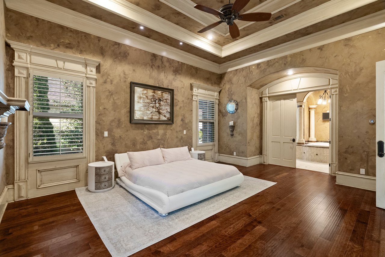 Main-level primary suite with fireplace, sitting area, wood floors, and private retreat-style layout.