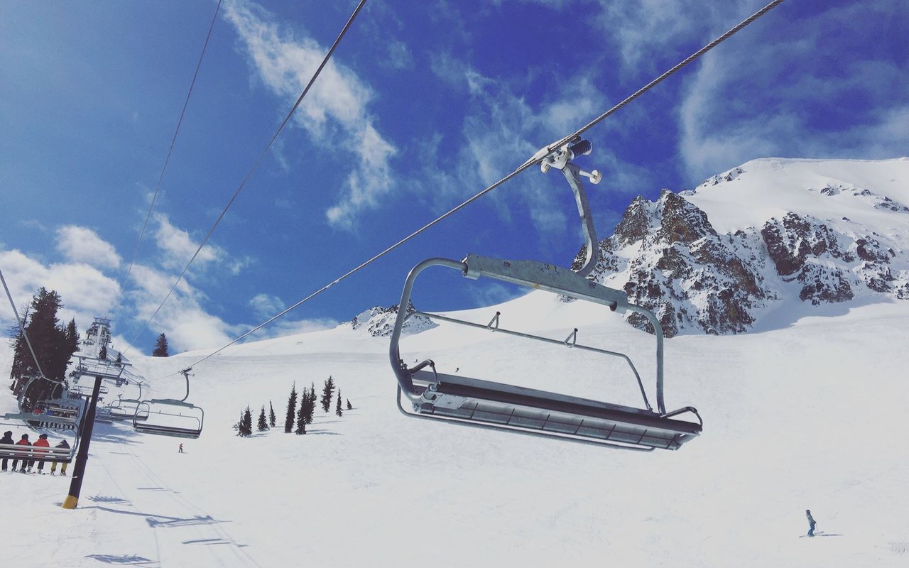 Squaw Valley ski slopes with an empty chairlift and snow-covered mountain peaks.