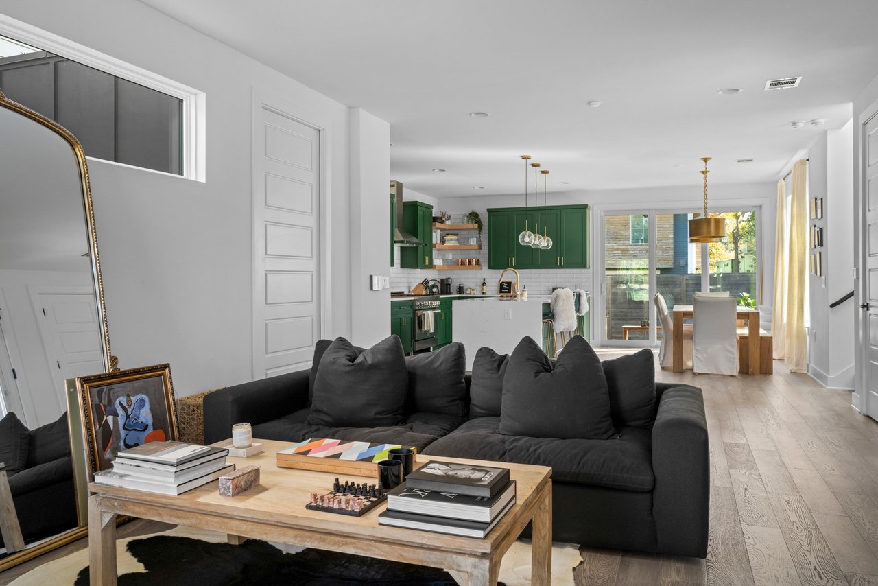 Open-concept living, kitchen, and dining space at 404 Powell Cir Unit B, Austin, TX, with sliding glass doors opening to the backyard.