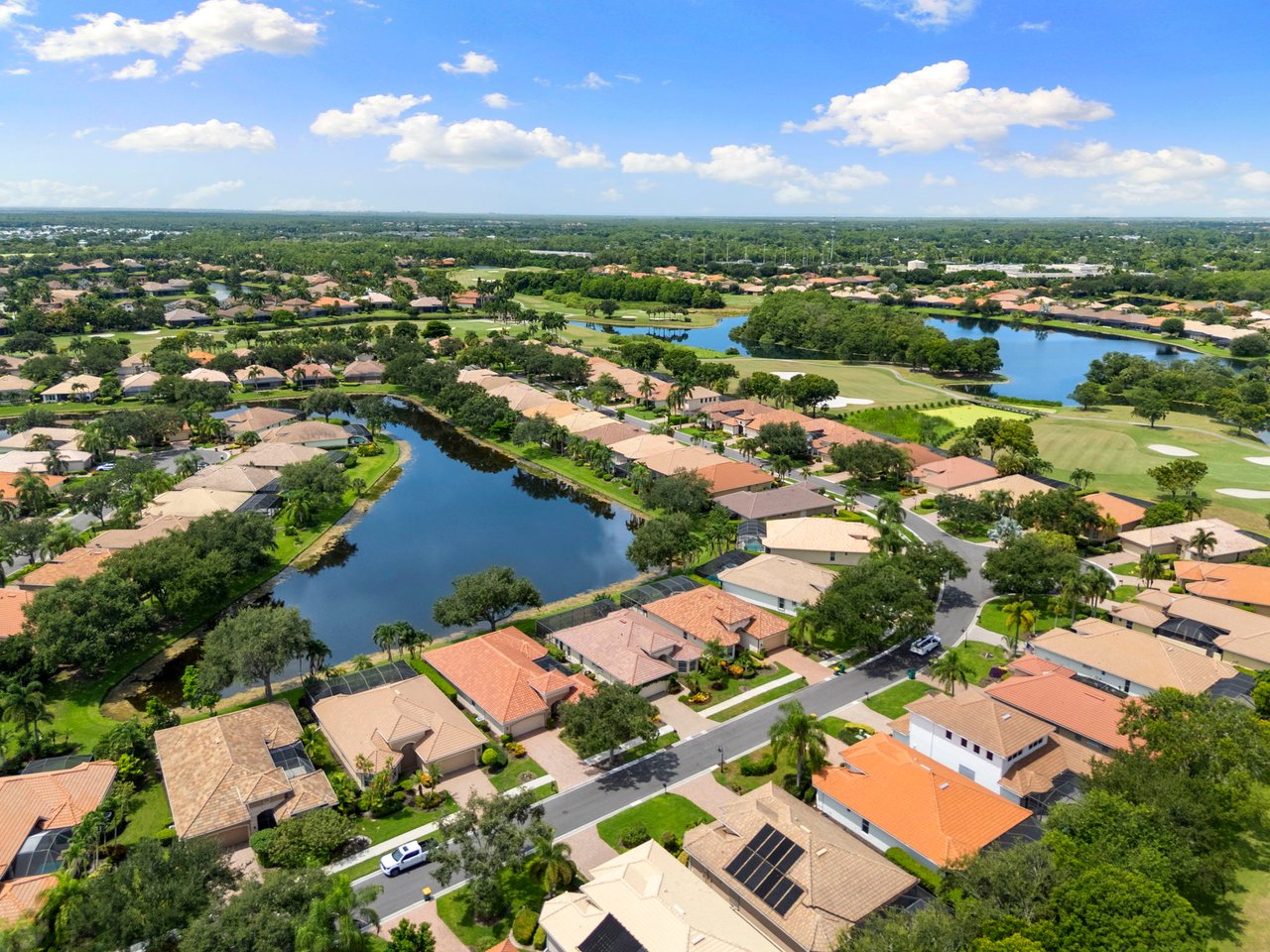 Aerial view of homes beside winding waterways and golf course fairways in Lely Resort.