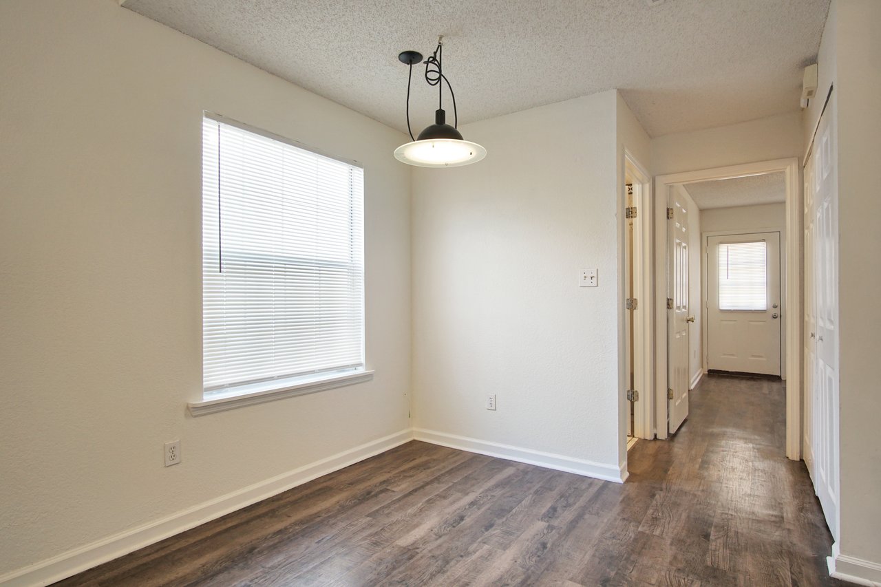 An empty room featuring hardwood floors and pristine white walls, creating a bright and spacious atmosphere.