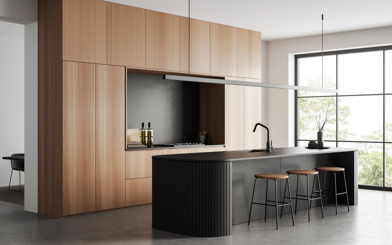Modern kitchen with light wood cabinets, a curved dark island, and three bar stools.
