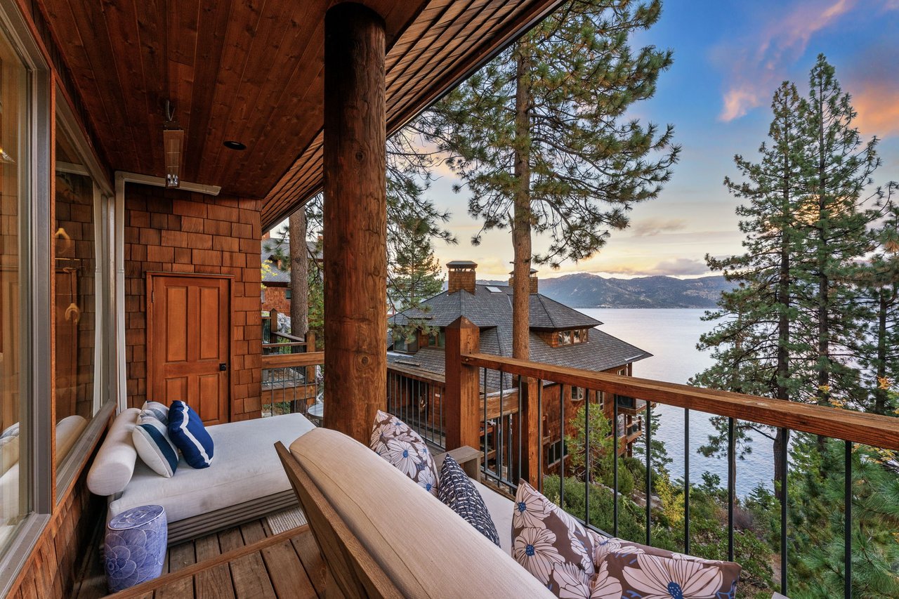 Lakefront balcony of a Crystal Bay second home overlooking Lake Tahoe at sunset, cedar shake exterior, mountain views