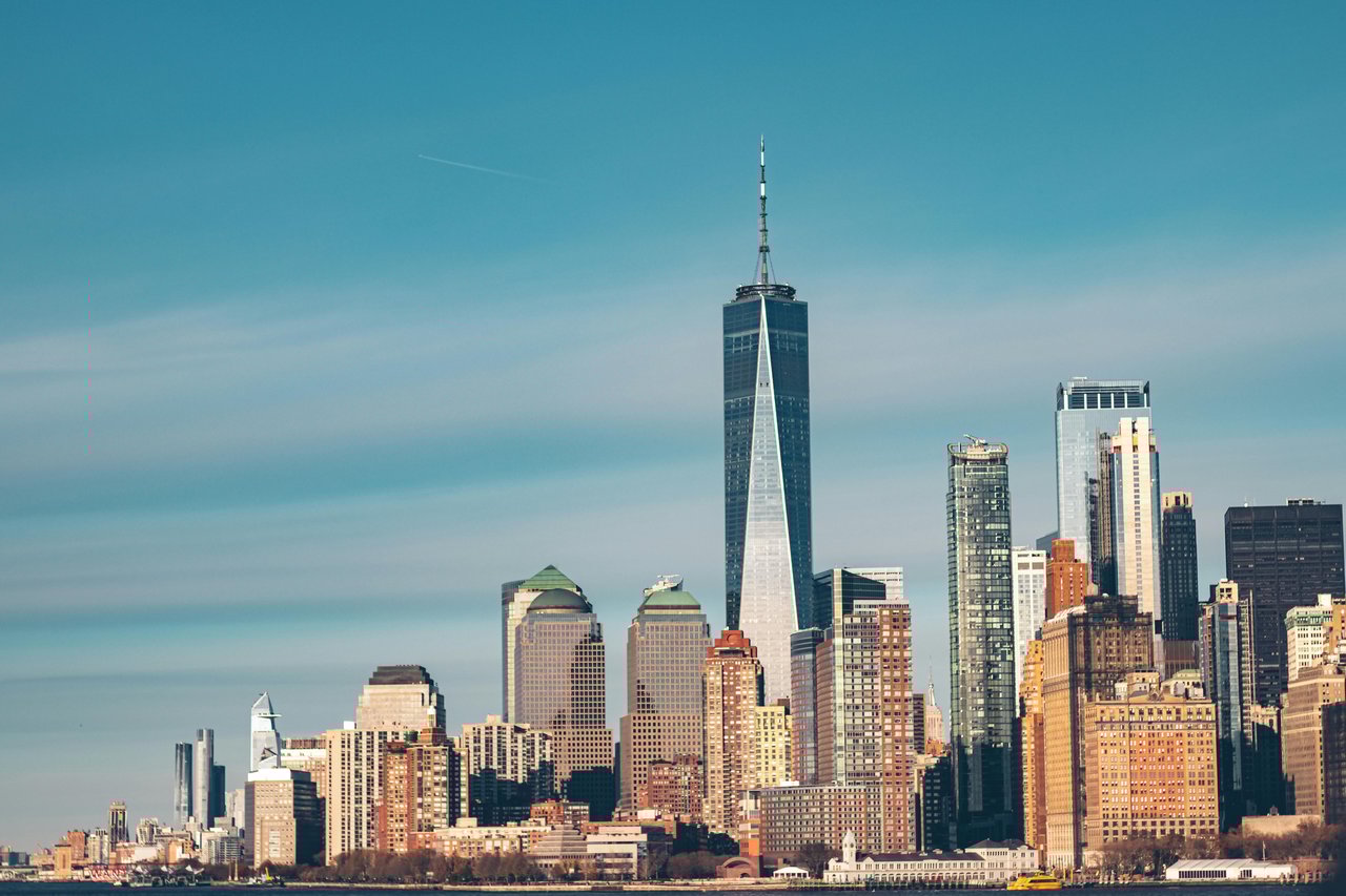 Financial District skyline in Manhattan featuring One World Trade Center and luxury high-rise apartments.