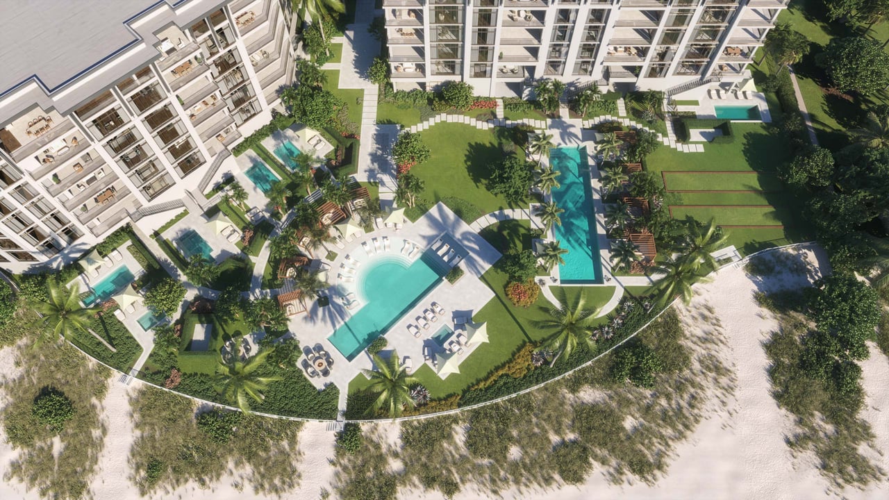 Rosewood Residences Naples towers surround landscaped grounds, swimming pools, and a sandy shoreline.