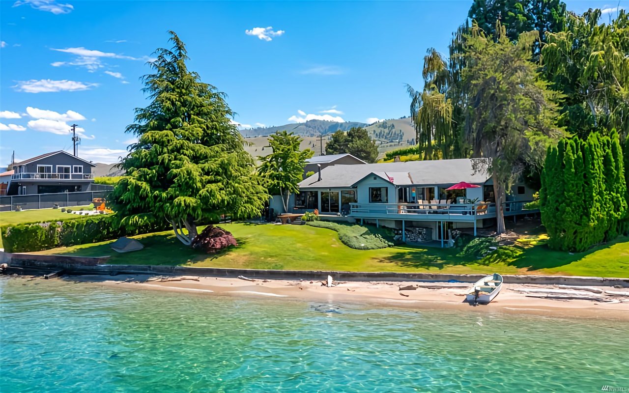  An expansive view of a waterfront property with a large, traditional-style house