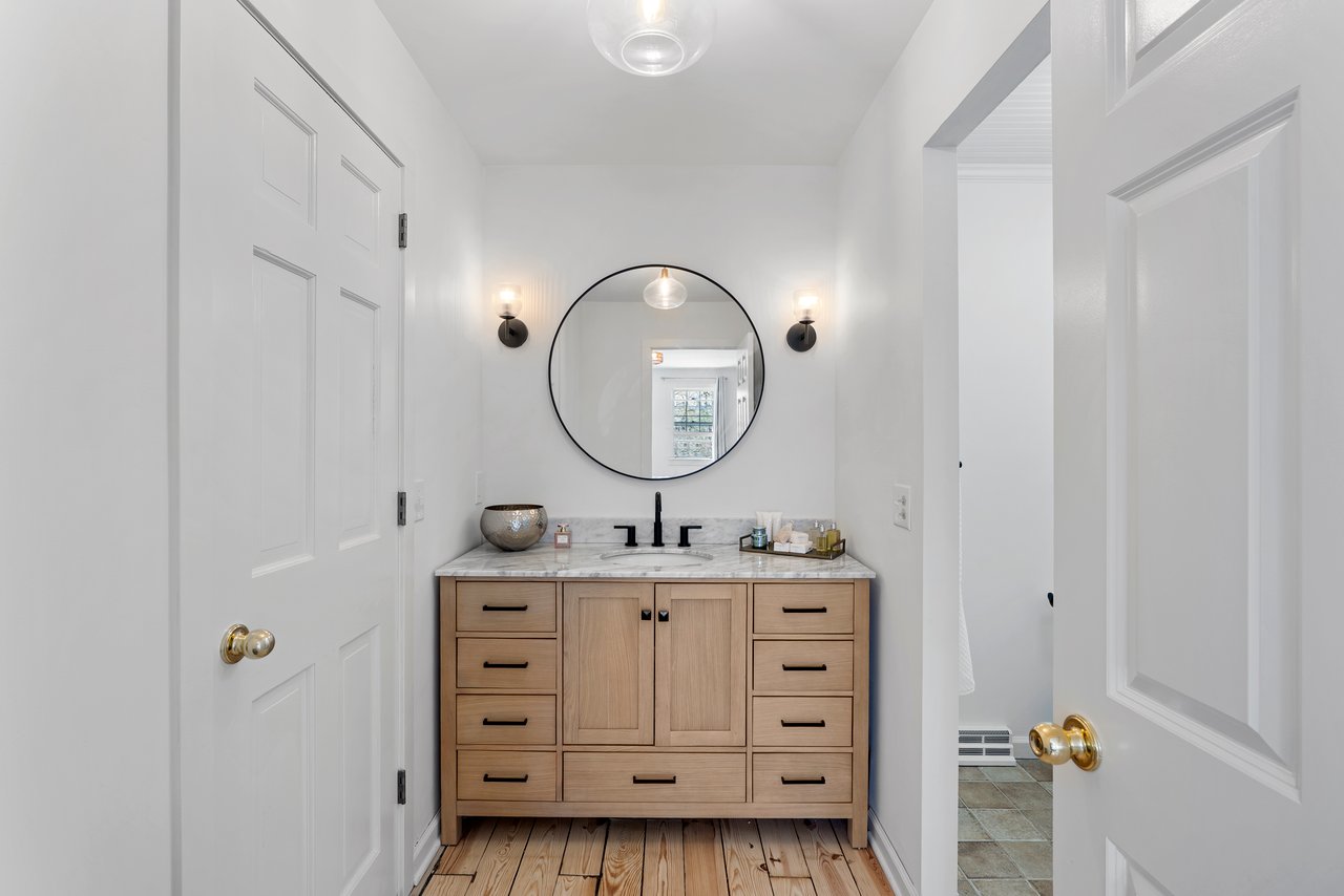 Renovated bathroom vanity at 7 Shaw Drive Simsbury CT with marble countertop and modern lighting