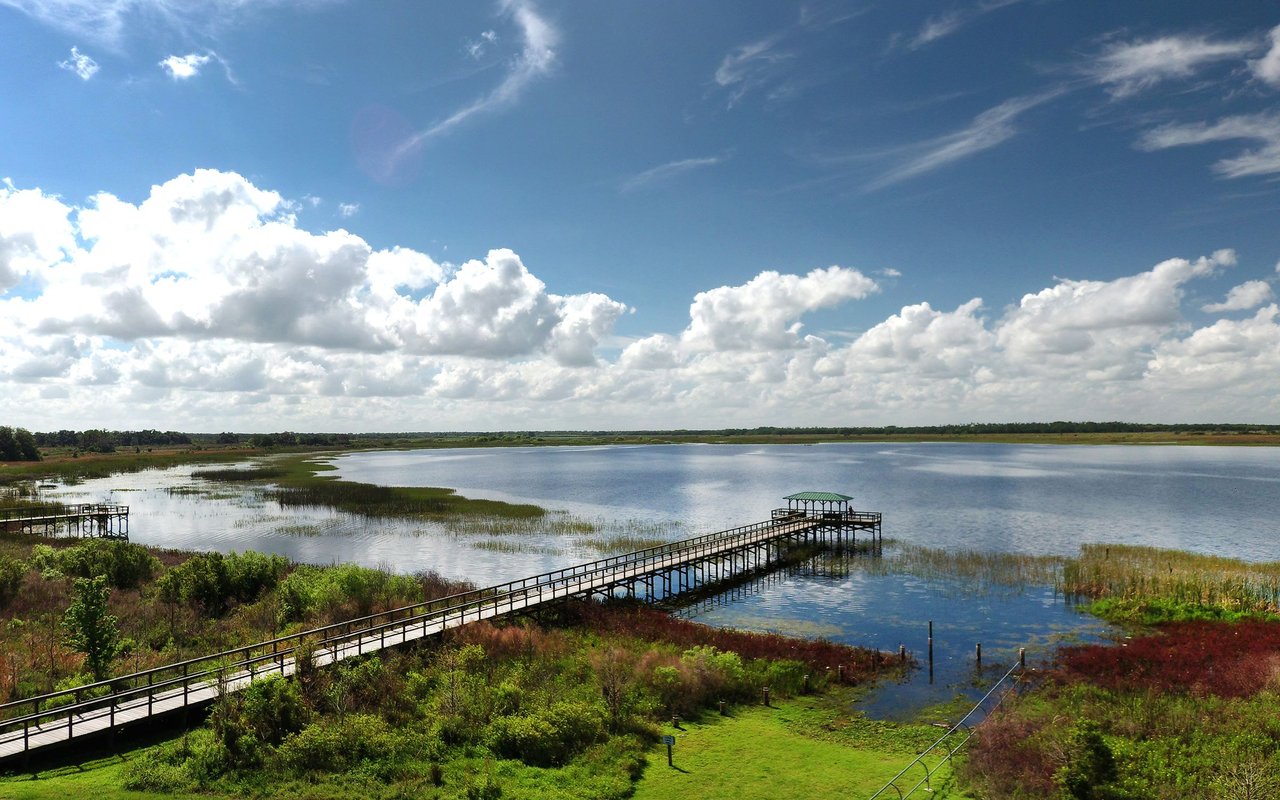 Lake and wetlands with a long boardwalk leading to a covered viewing platform.