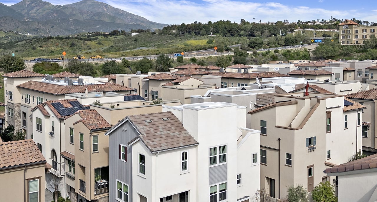 Aerial view of townhomes in a Mission Viejo community, with Saddleback's peaks in the distance.