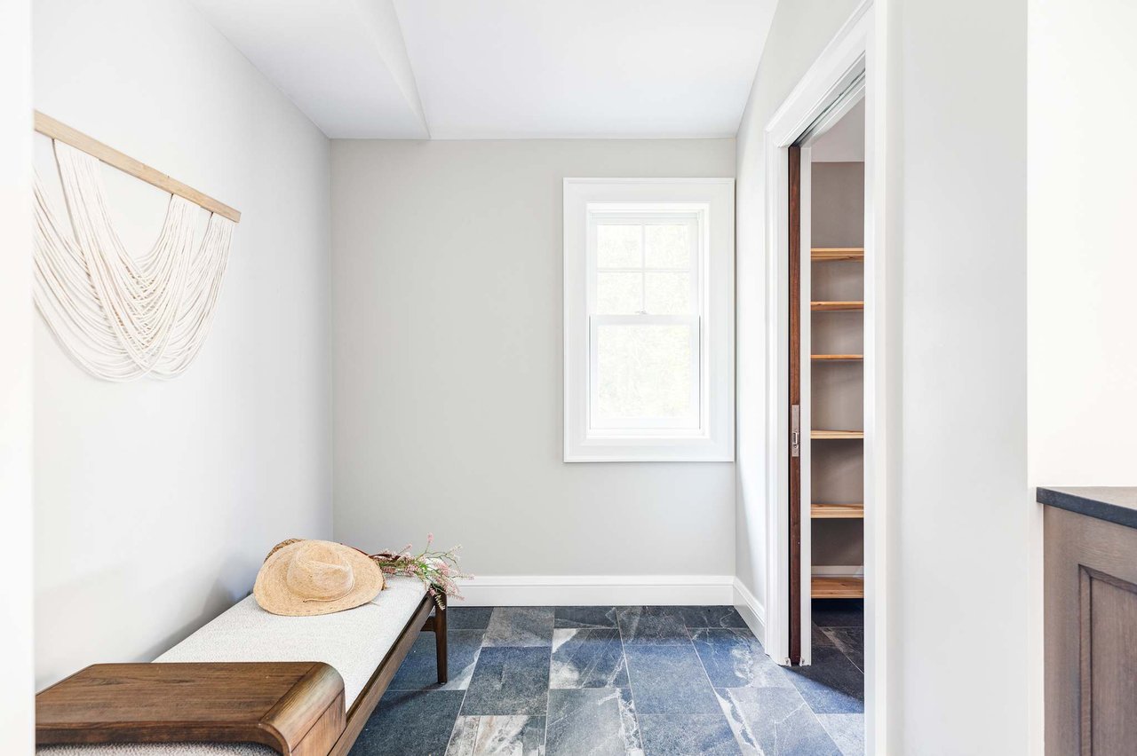 Modern mudroom with slate floors, built-in bench, and macrame wall hanging