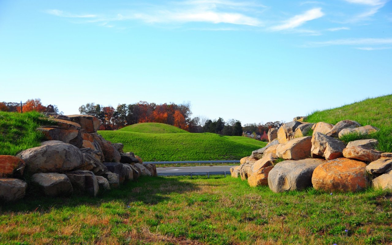 Autumn, hilly, green pastoral scene with large stone hills on the right and left of the image