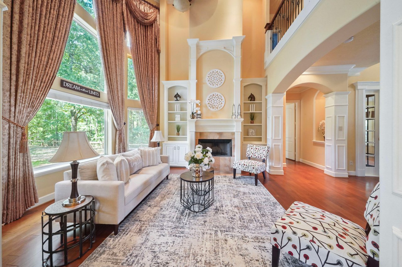 Amazing formal Living area with fireplace, custom built-ins, and 24 ft. ceiling. The floor to ceiling pciture windows provide an amazing view of Crown Lake and the resident deer that flock to the lake on occasion