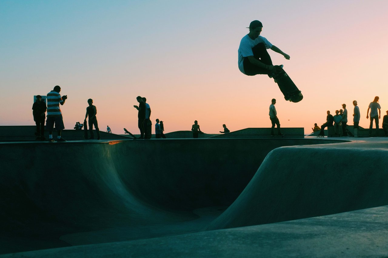 A group of people with their skateboards at a skatepark.