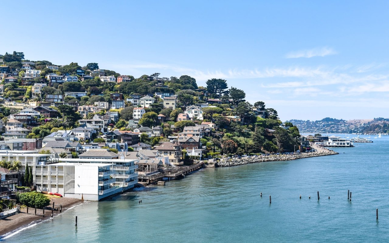 A row of colorful houses perched on a hill overlooking the San Francisco Bay in Sausalito, California.