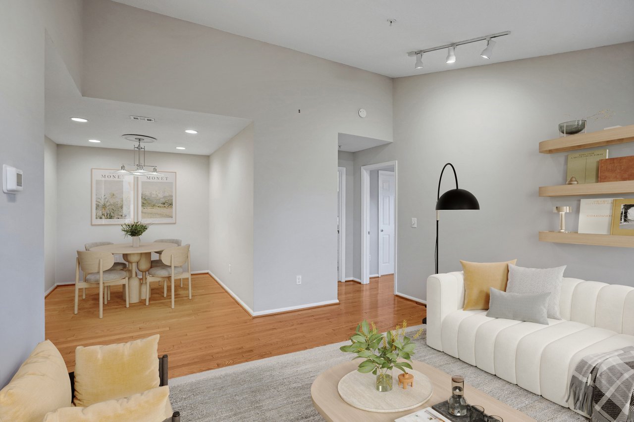 Open living and dining area with hardwood floors, white sofa, and floating wood shelves.