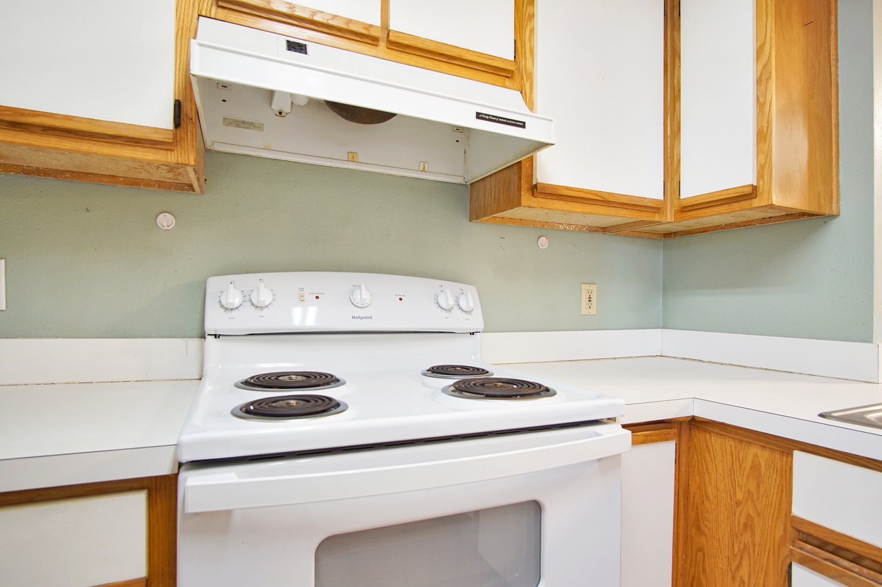 A modern kitchen featuring a stove and a sink, showcasing a clean and functional design.