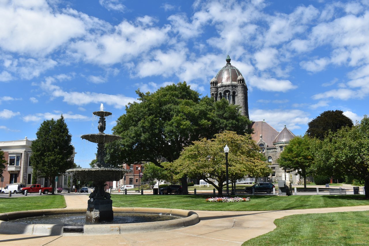 Taunton town green with a tiered fountain and a stone building with a domed tower.
