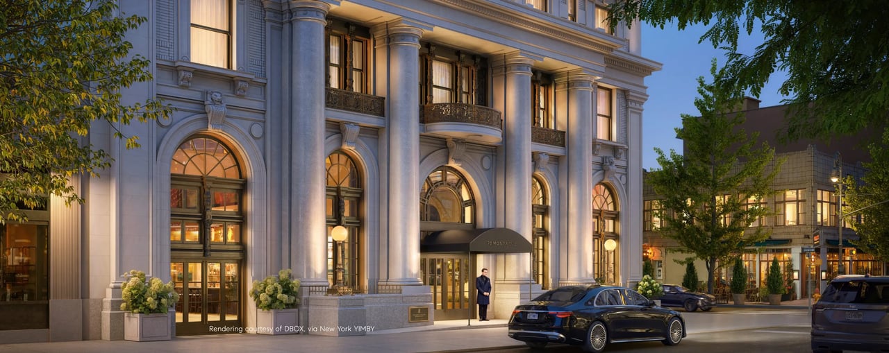 Grand stone building with columned facade and arched windows, warmly lit at dusk.