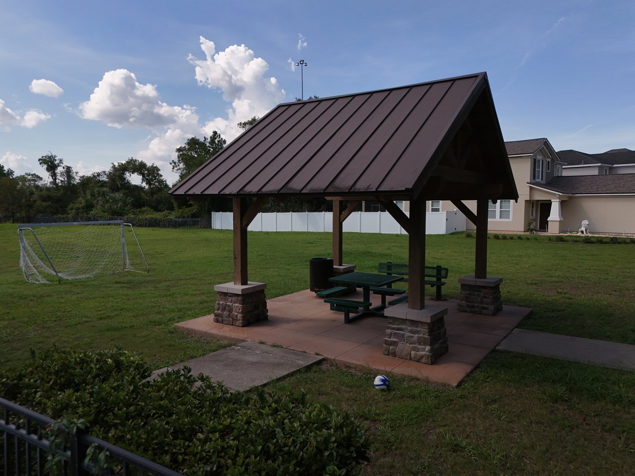 Neighborhood pavilion with picnic tables beside a soccer goal and grassy lawn.