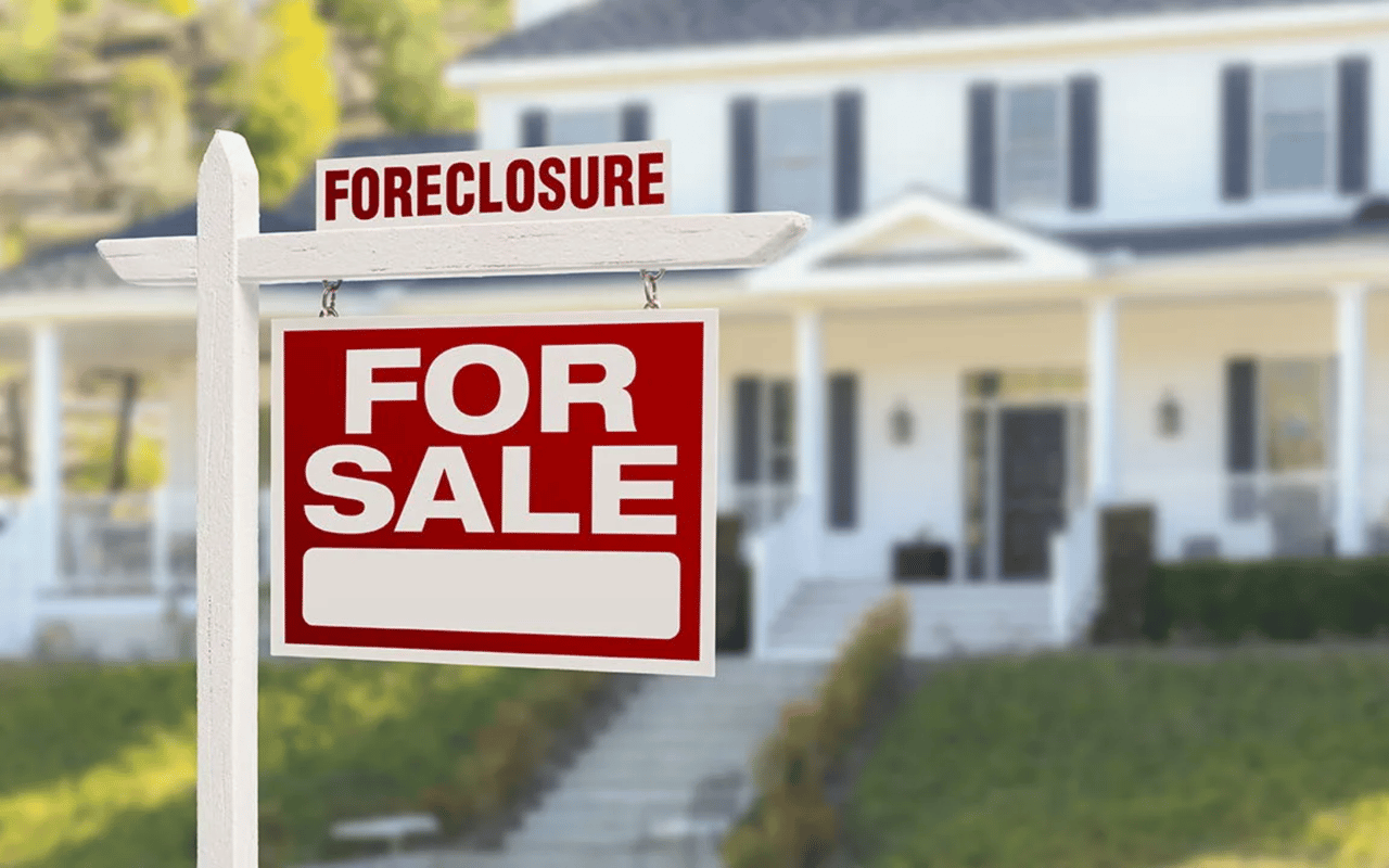 Foreclosure and for-sale signs in front of a detached house.