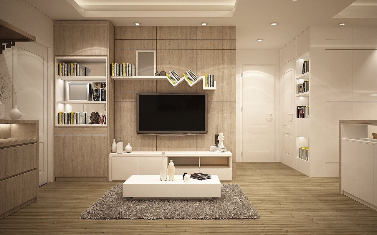 Contemporary living room with a paneled TV wall, built-in bookcases, and a white coffee table.