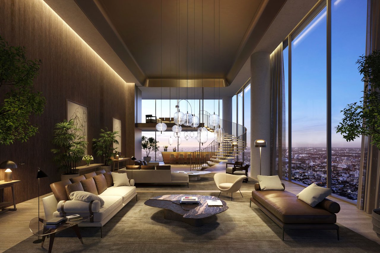 Double-height living room with a curved staircase, sculptural pendant lights, and floor-to-ceiling city views.