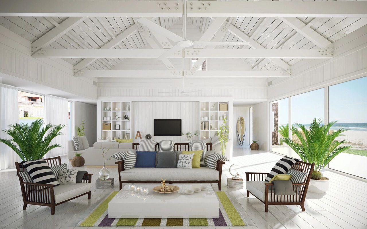 Bright living room with a vaulted white ceiling, striped seating, and ocean views.