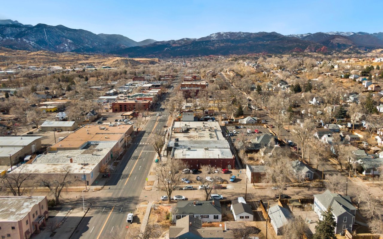 An aerial view of a small town nestled in a valley surrounded by mountains