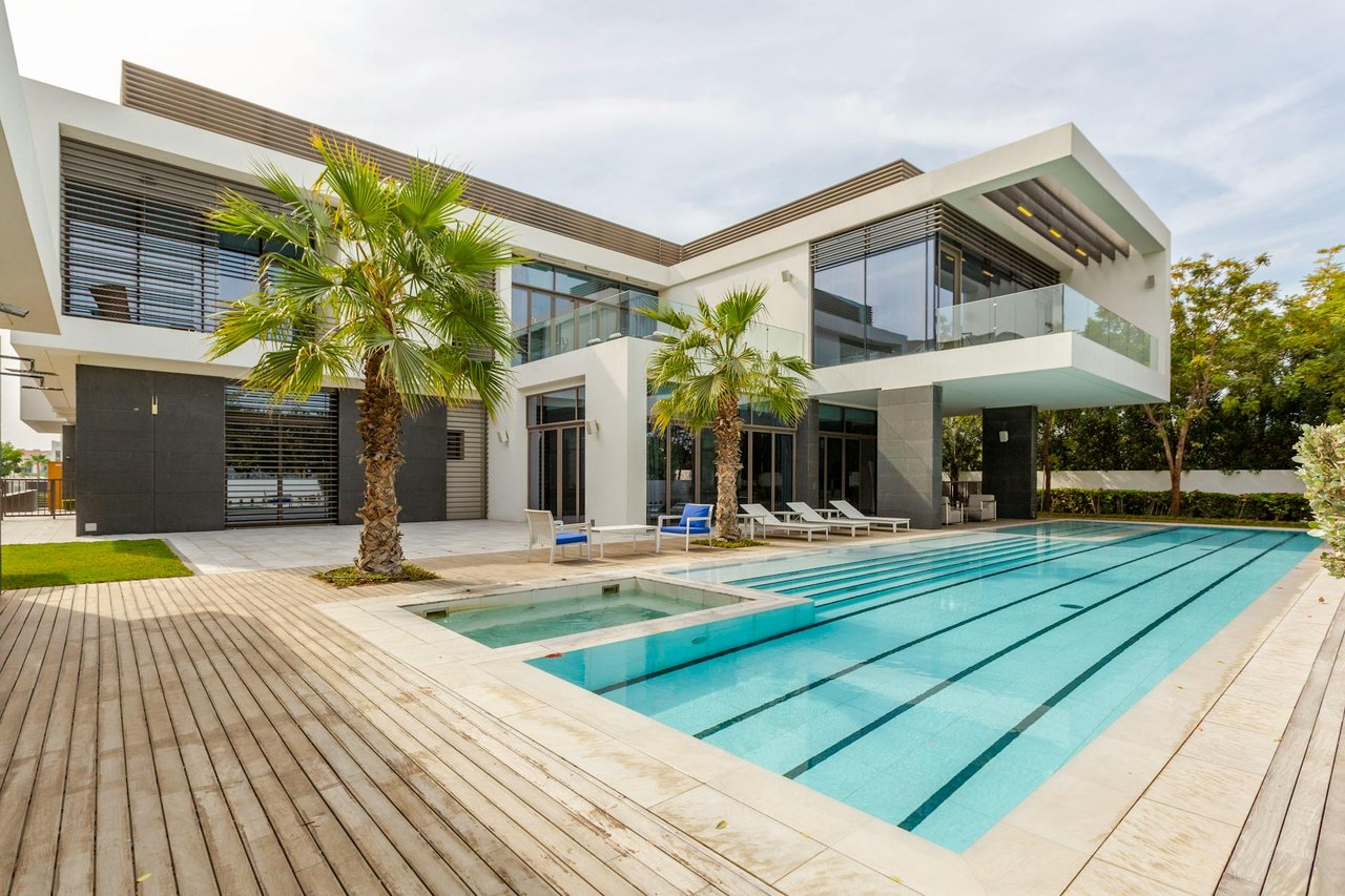 Modern luxury villa with private swimming pool, palm trees, and contemporary open-plan architecture
