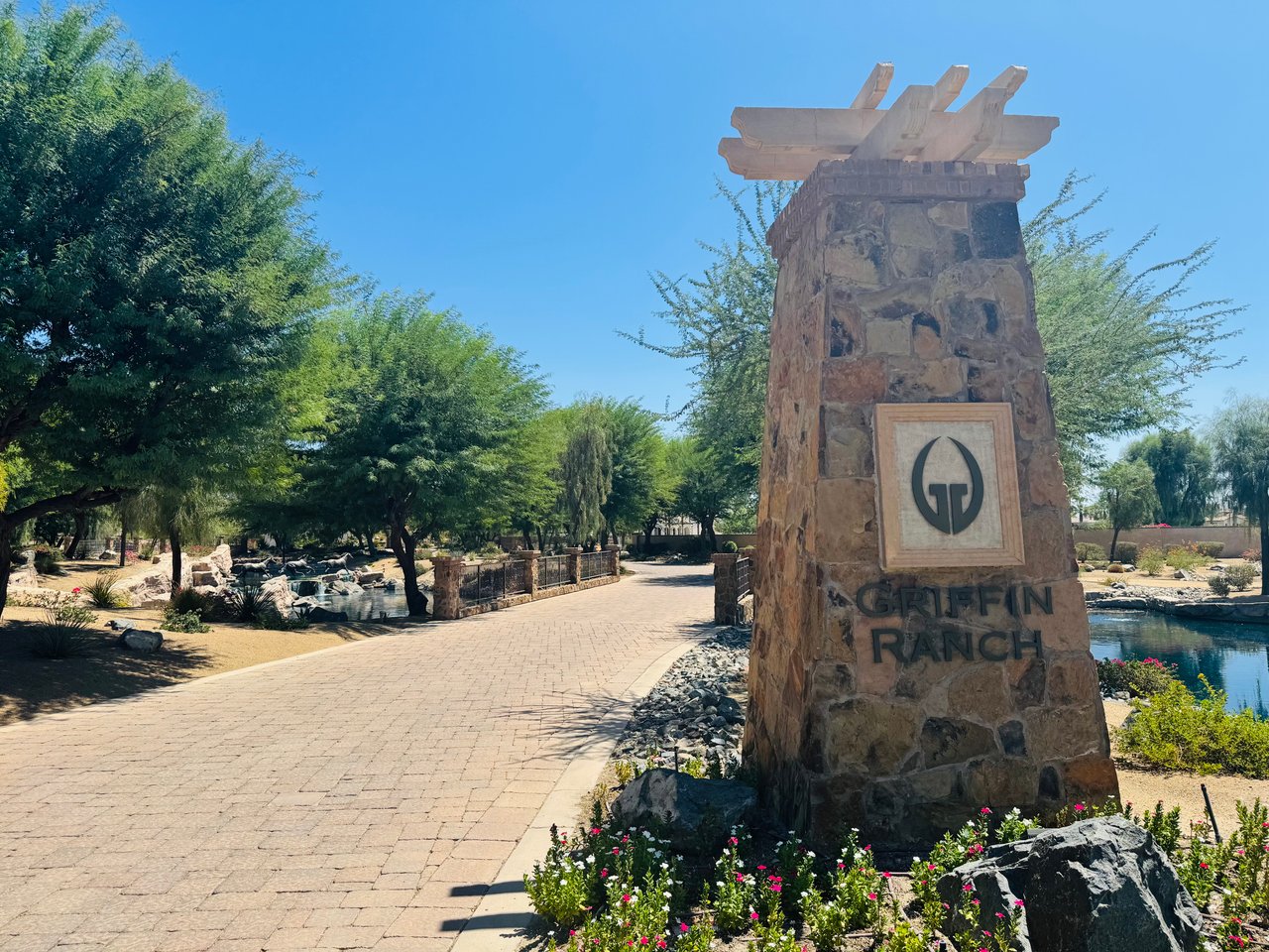 Griffin Ranch entrance marked by a stone monument sign beside a landscaped walkway and water feature.