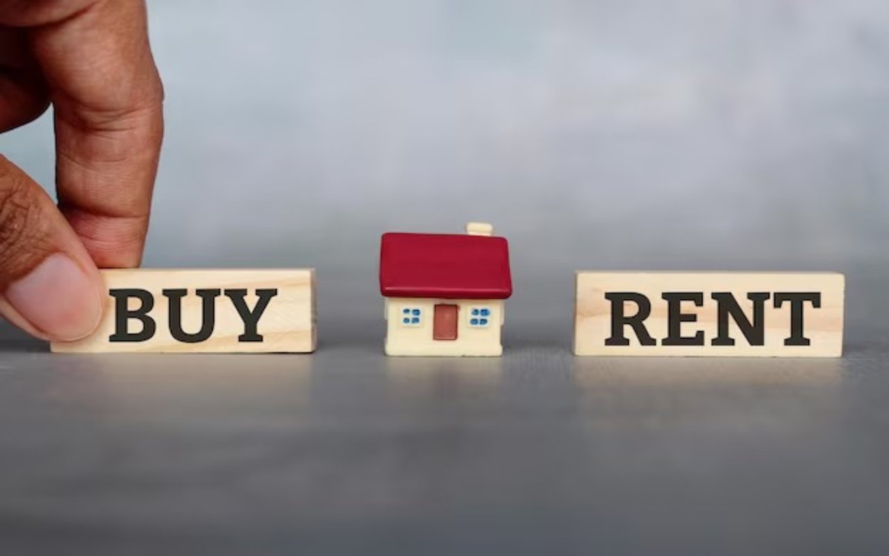 A hand reaches toward BUY beside a model house and a RENT block.