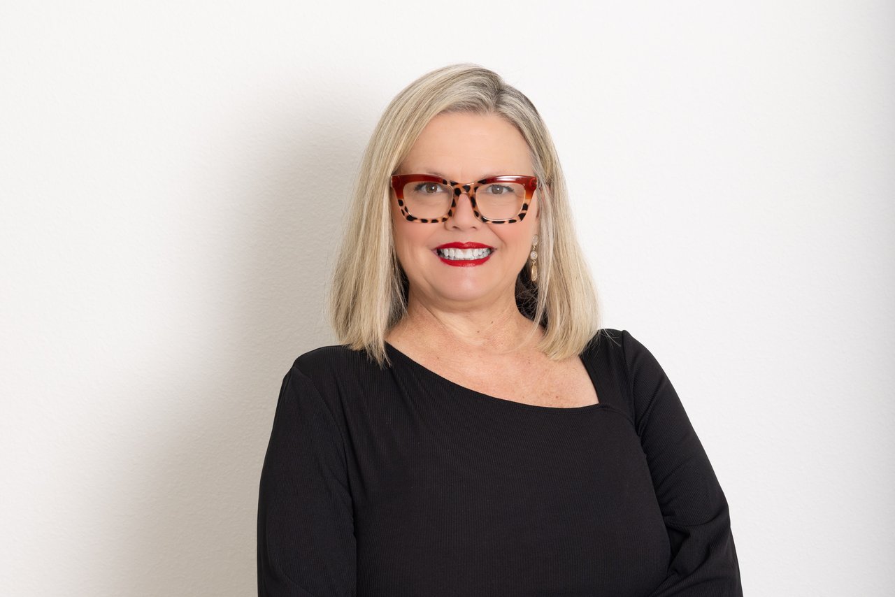 Melissa Miller smiling in tortoiseshell glasses and a black top.
